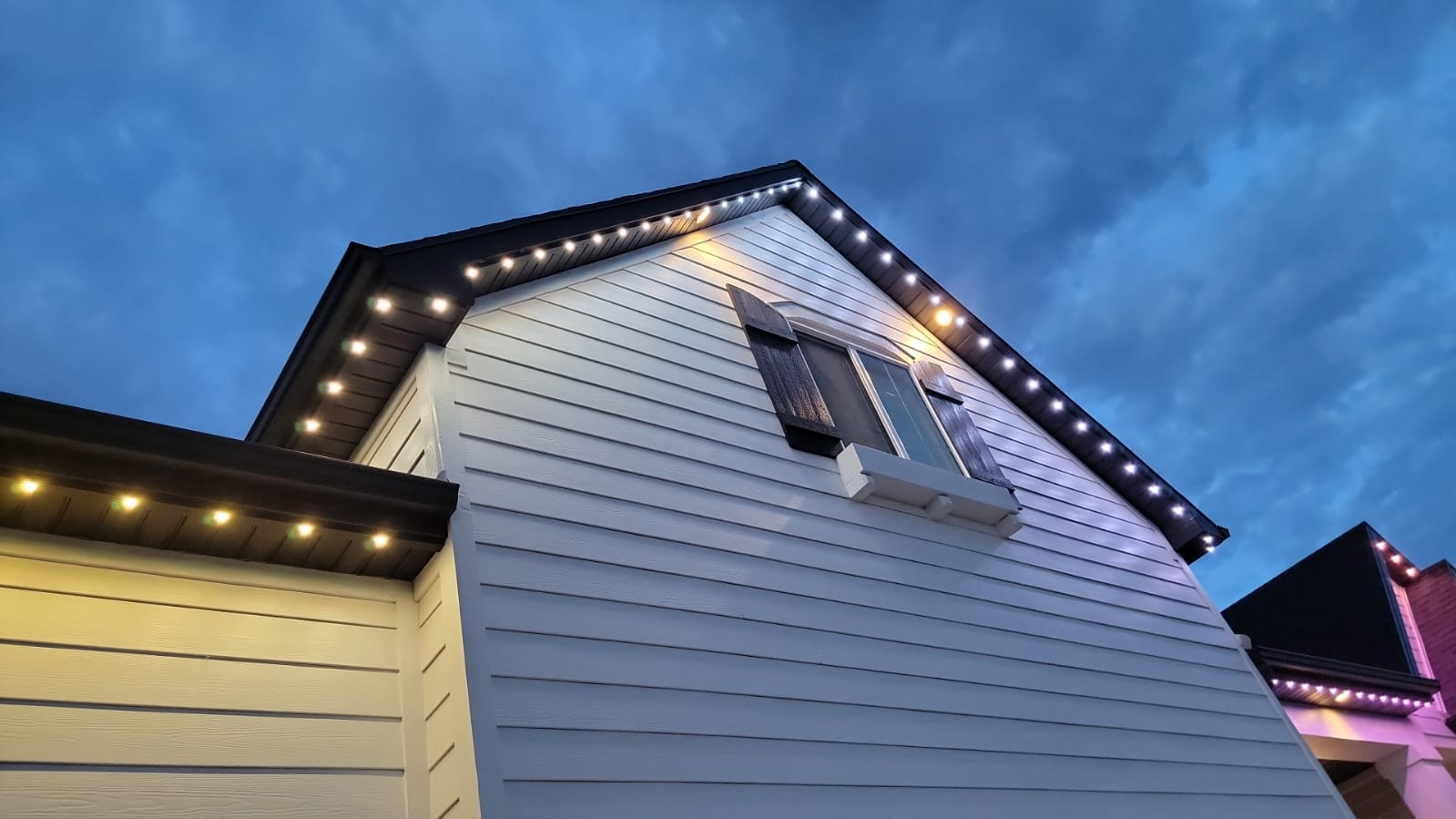 Alberta luxury home with color-changing permanent outdoor lighting showcasing landscape